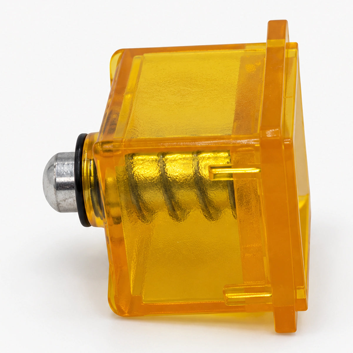Side view of a yellow coin reject button showing its internal spring and metal plunger