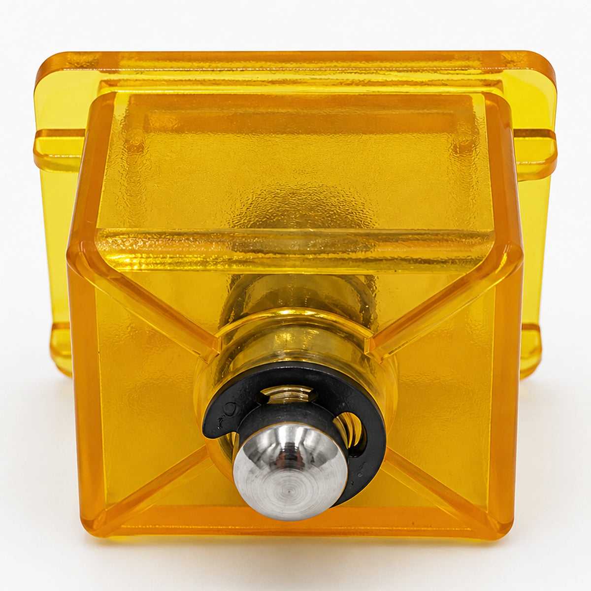 Translucent yellow coin reject button showing its rear housing and central metal shaft.